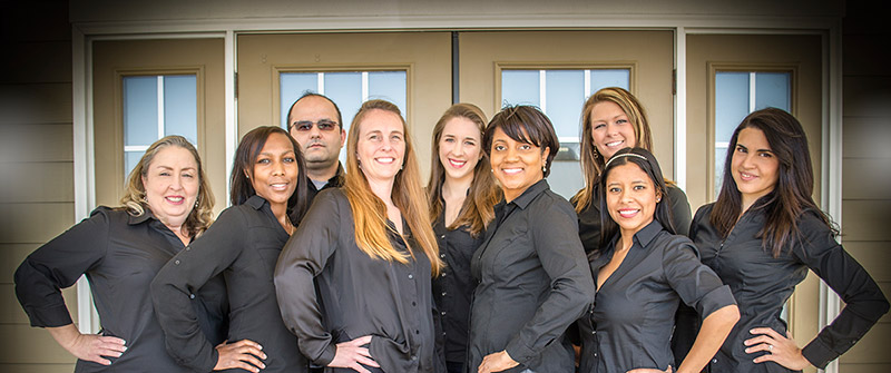 Photo of the Day & Night Family Dental team standing in front of the dental office