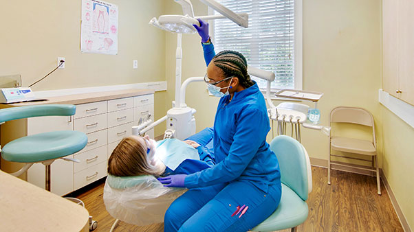 dental hygienist cleaning teeth of patient